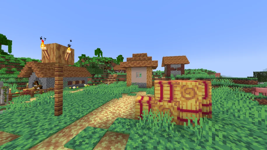Minecraft village with a pile of hay bales in the foreground with Gleam Things textures